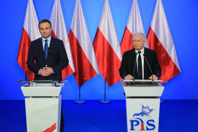 Deux hommes politiques polonais se tiennent derrière des pupitre. A la gauche, c'est le Premier ministre, à la droite, le président. 
