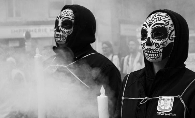 Deux personnes déguisées en mort avec de la fumée blanche autour lors d'une manifestation