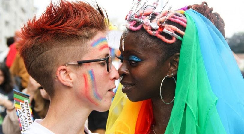 deux femmes qui sont sur le point de s'embrasser au milieu d'une foule compacte à la Pride de l'inter-LGBT de 2021